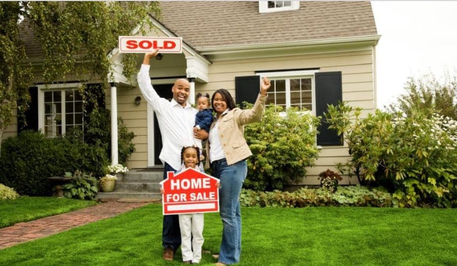 A family celebrating outside their newly bought home