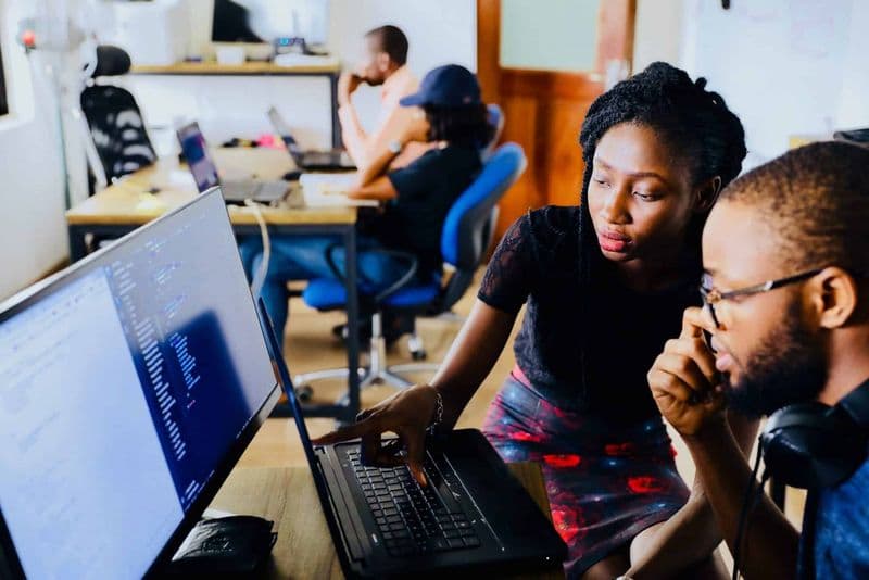 Two colleagues working through results on their screens
